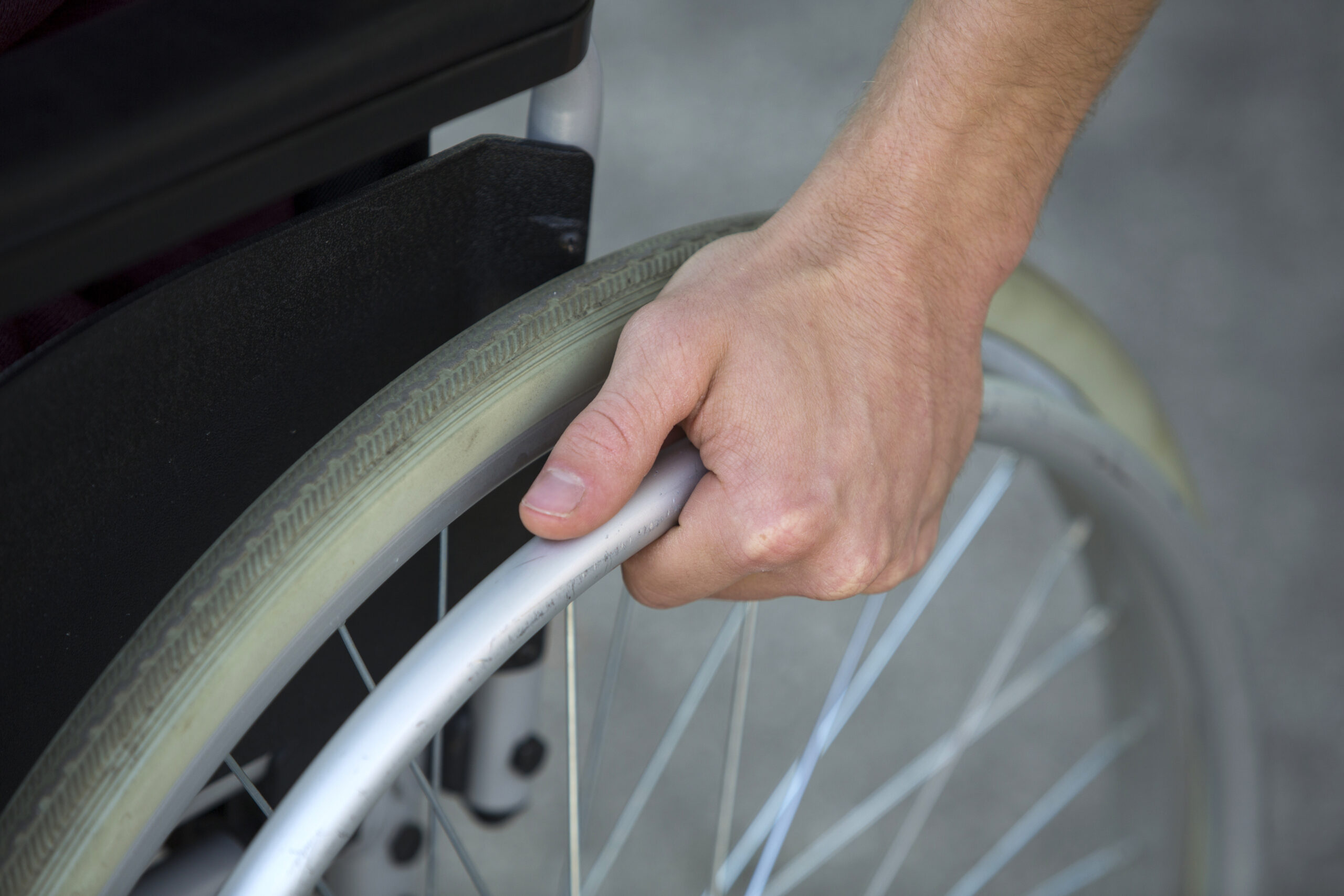 closeup of man in wheelchair holding wheel